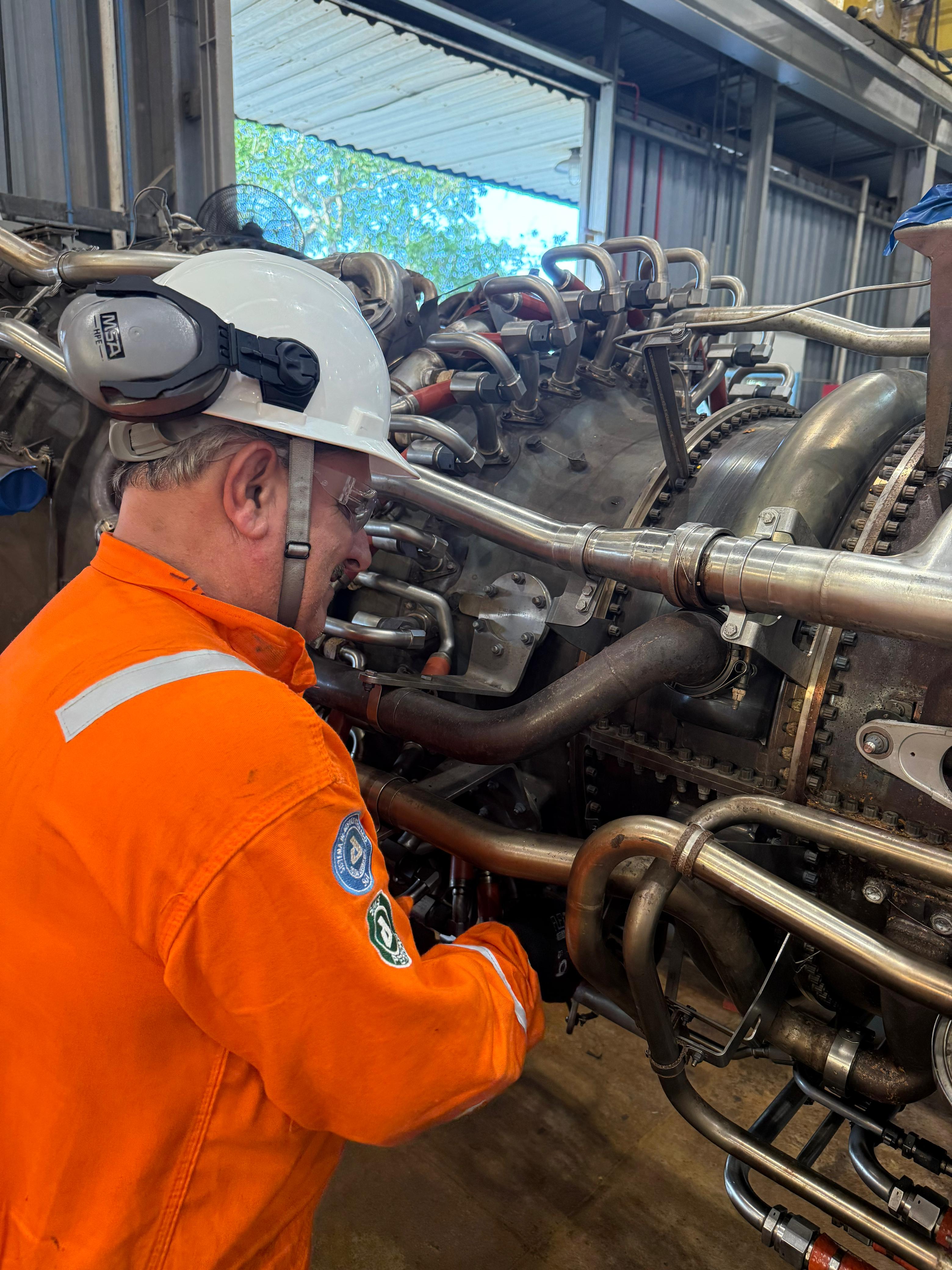 Técnico atuando em uma turbina a gás em ambiente industrial